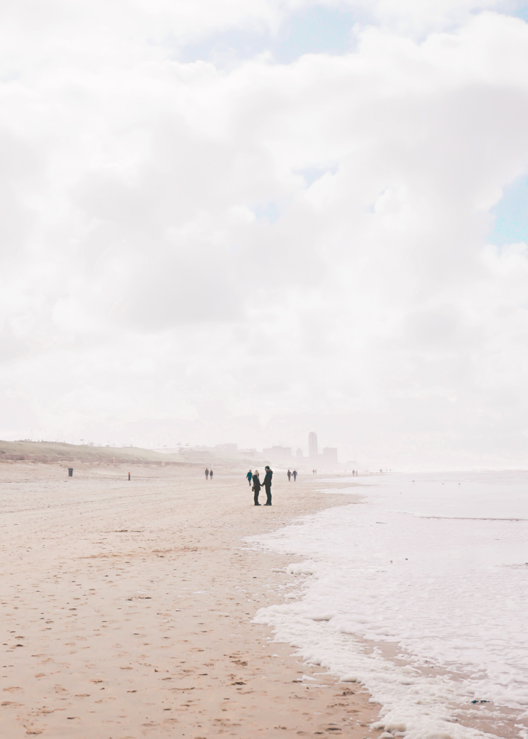 Couple holding hands along Bloemendaal ann Zee beach